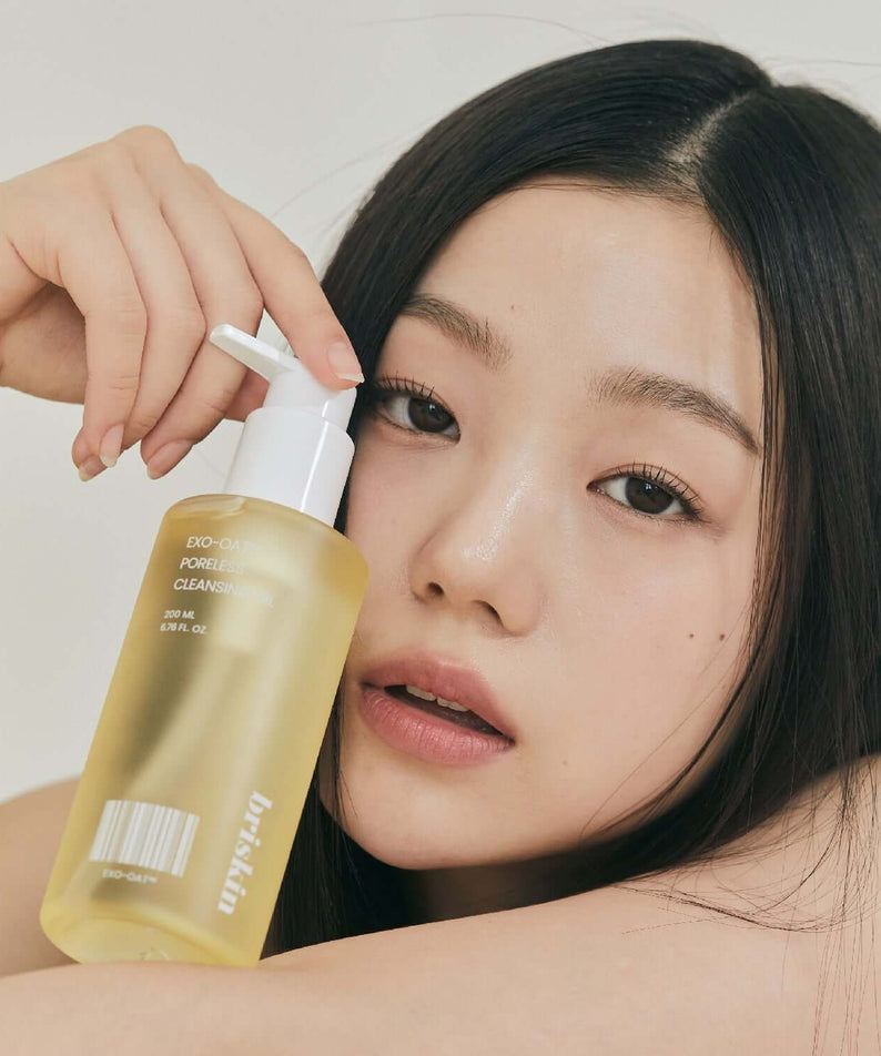 Woman holding BRISKIN Exo-Oat Poreless Cleansing Oil 200ml bottle
