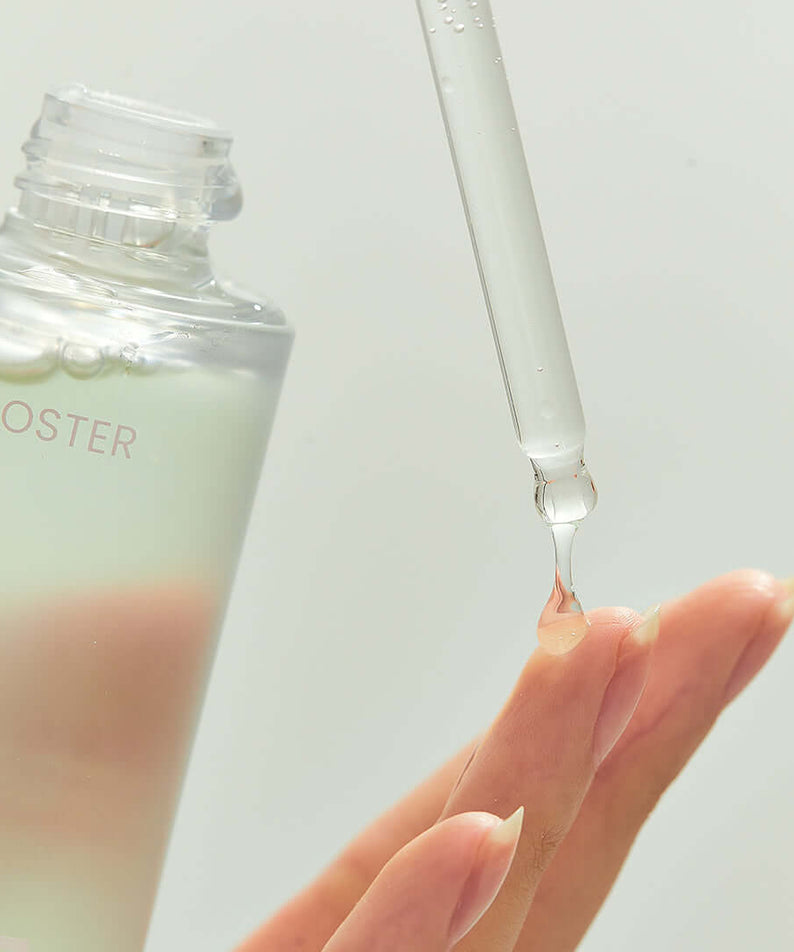 Close-up of BRISKIN Houttuynia Cordata Exo-Barrier Skinbooster Serum 50ml being applied with a dropper to fingertips.