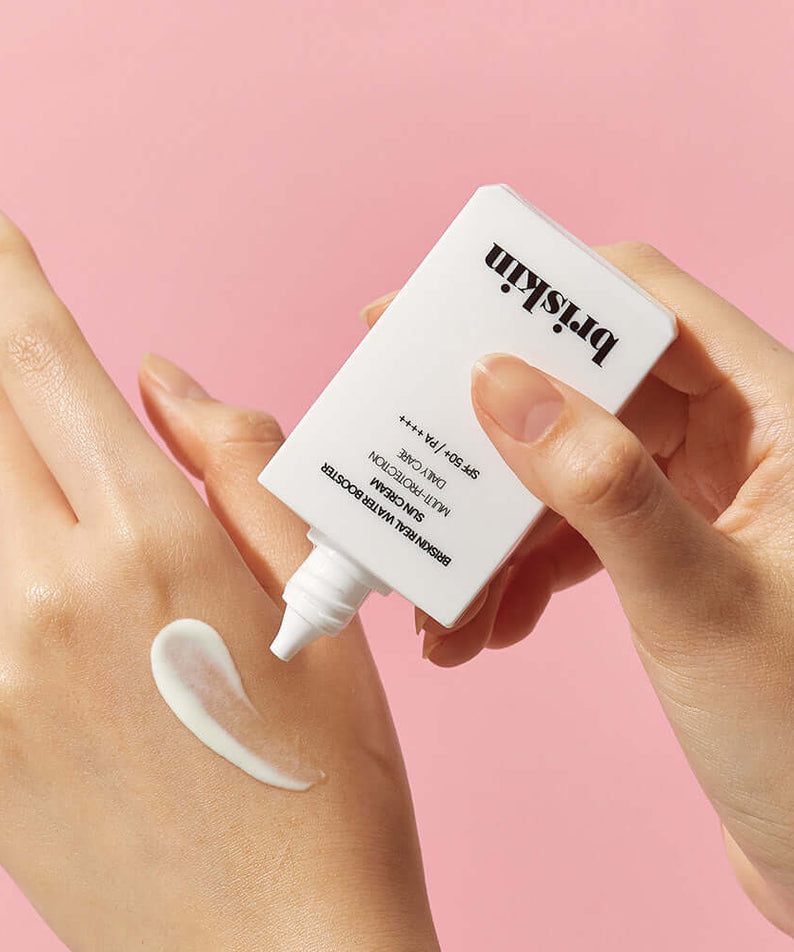 BRISKIN Real Water Booster Sun Cream SPF+PA++++ 50ml being applied to hand against pink background