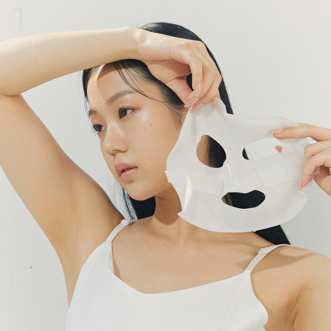 Woman applying BRISKIN Selaginella Exopeptide Collagen Mask 5 sheets on face