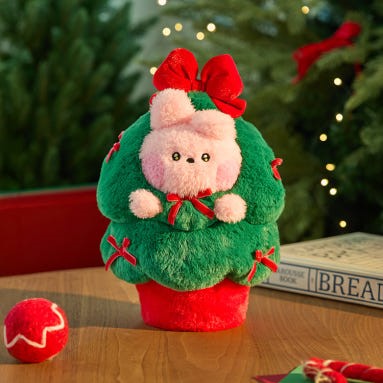 BT21 Minini Petit Holiday Tree Plushy avec décor festif sur une table en bois, idéal pour des célébrations de Noël chaleureuses.