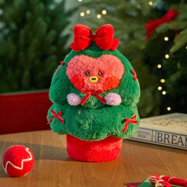 BT21 Minini Petit Holiday Tree Plushy adorable vert et rouge décoratif sur une table, parfait pour les fêtes de fin d'année.