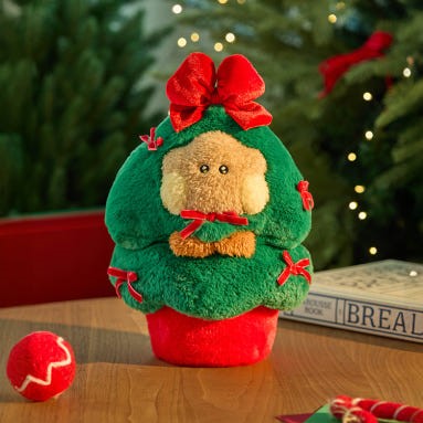 BT21 Minini Petit Holiday Tree Plushy avec un design festif de Noël, placé sur une table décorée avec des ornements.