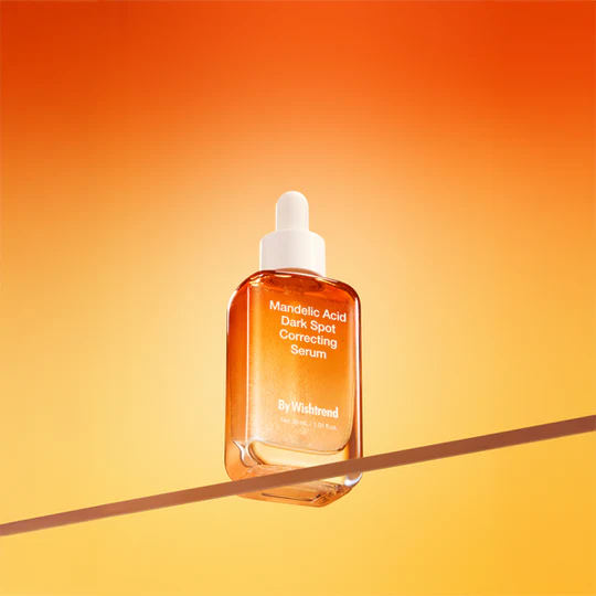 BY WISHTREND Mandelic Acid Dark Spot Correcting Serum 30ml product bottle against an orange background.