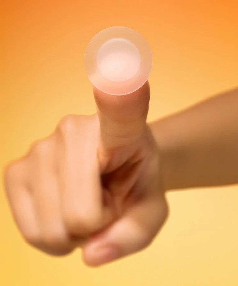 Person holding a BY WISHTREND Mandelic Acid Spot Clearing Patch 39 Patches against an orange background.