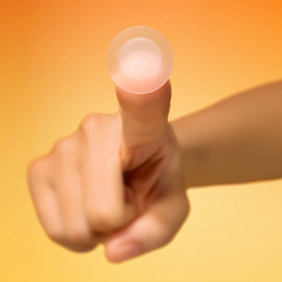 Person holding a BY WISHTREND Mandelic Acid Spot Clearing Patch 39 Patches against an orange background.