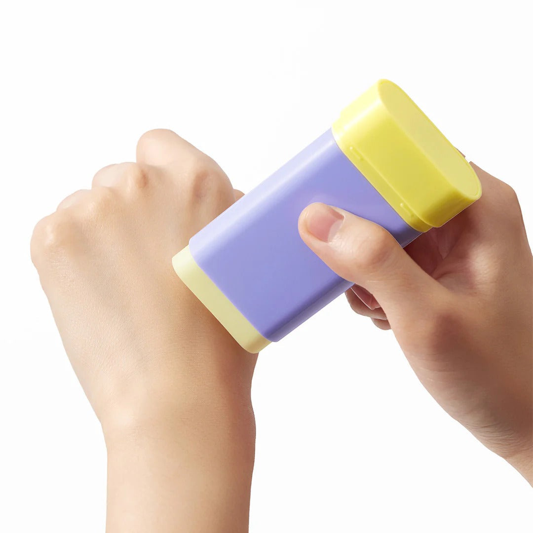 Applying BY WISHTREND Pore Smoothing Bakuchoil Sun Stick 18g on hand for sun protection and pore smoothing.