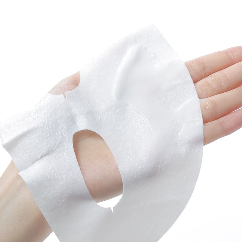 Hand holding CELIMAX Brightening Pore Blemish Cream Wrapping Mask 1 Sheets showing texture and application.