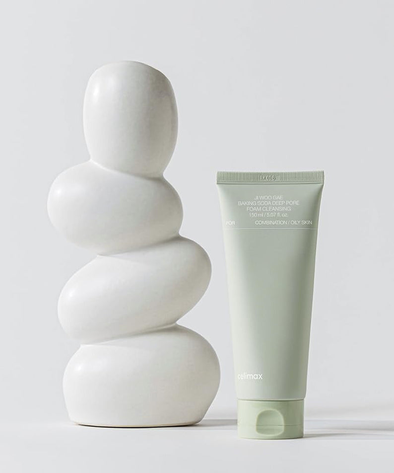 CELIMAX Ji Woo Gae Baking Soda Deep Pore Foam Cleansing 150ml tube next to white sculpture for facial care