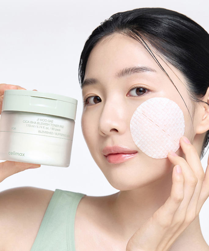 Woman using CELIMAX Ji Woo Gae Cica BHA Blemish Toner Pad 60 pads for skincare routine.