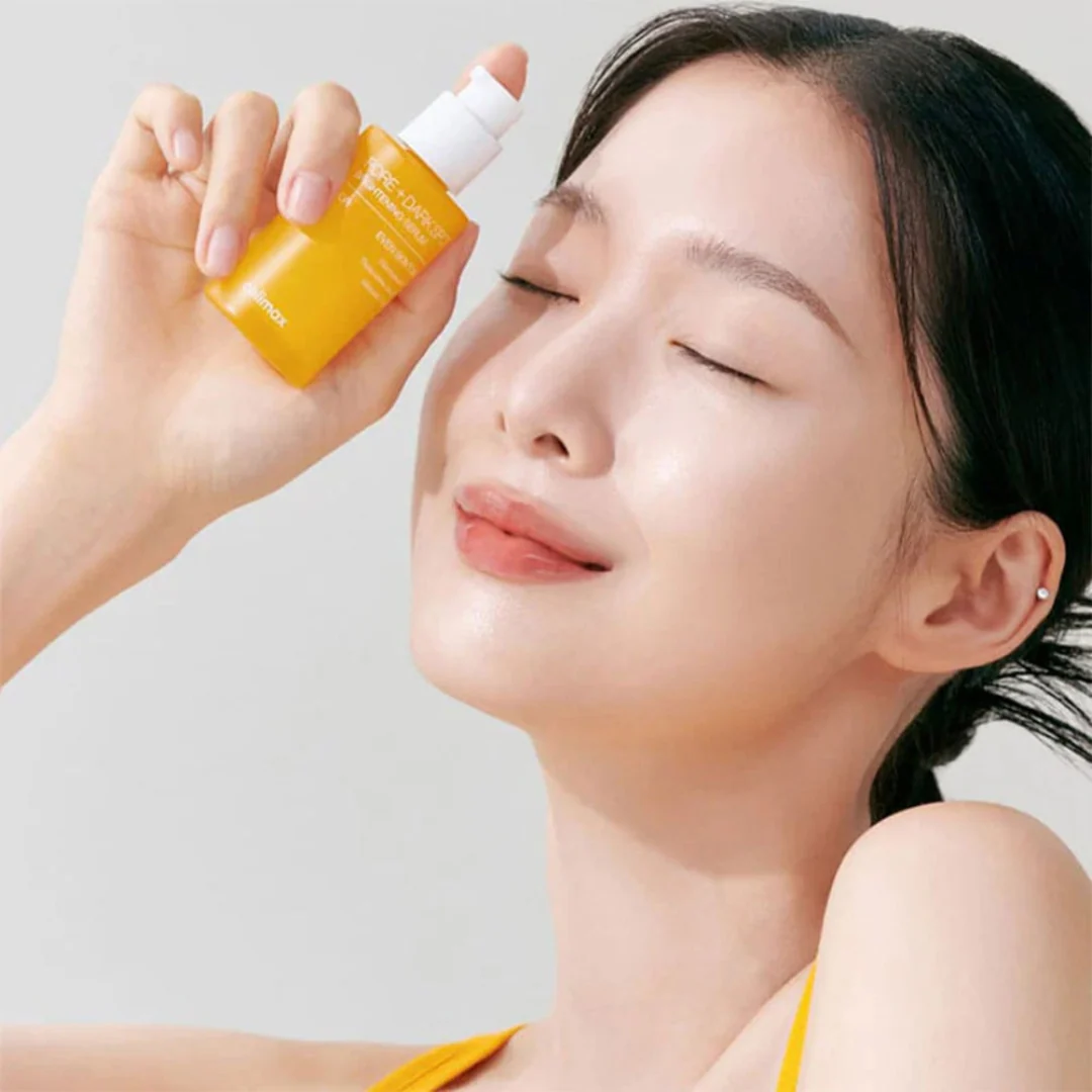 Woman holding CELIMAX Pore Dark Spot brightening Serum 30ml, showcasing glowing skin