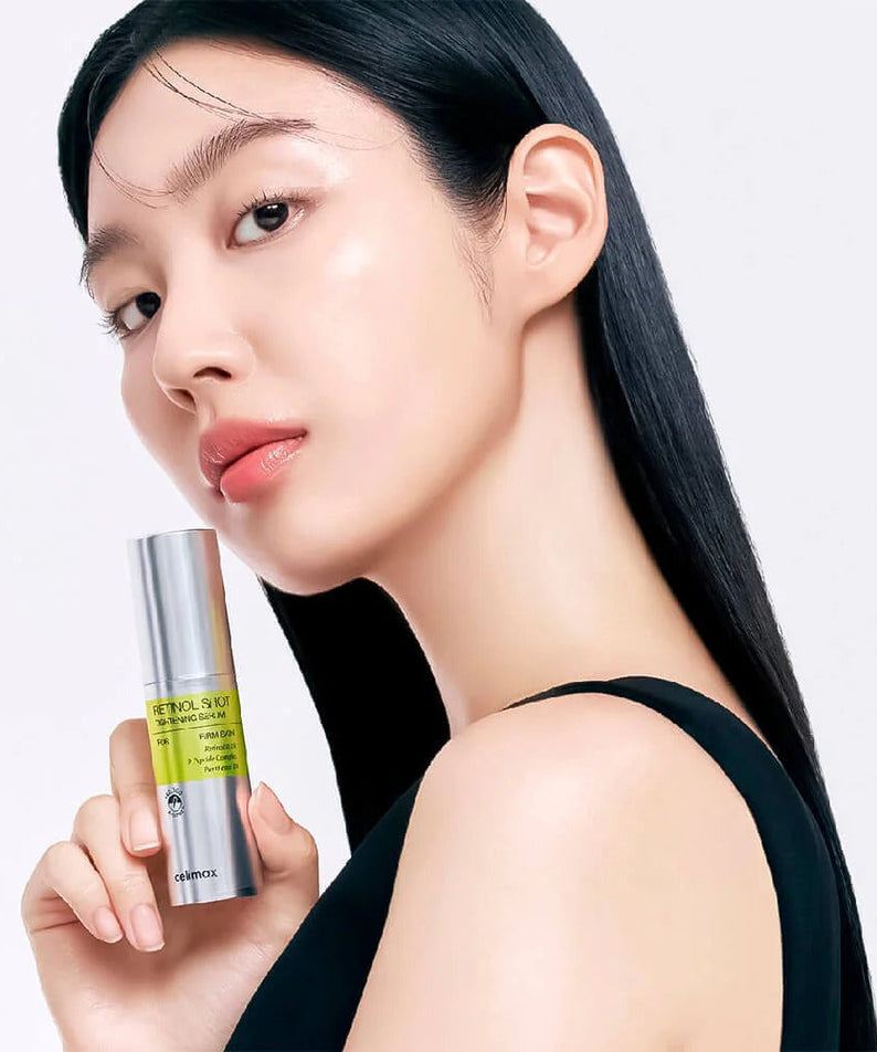 Woman holding CELIMAX Retinol Shot Tightening Serum 30ml against white background.
