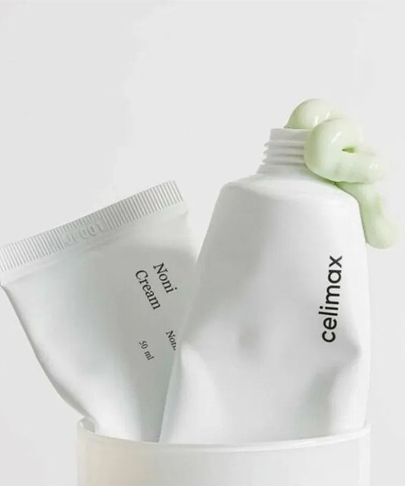 CELIMAX The Real Noni Energy Repair Cream 50ml tubes with cream texture on display.