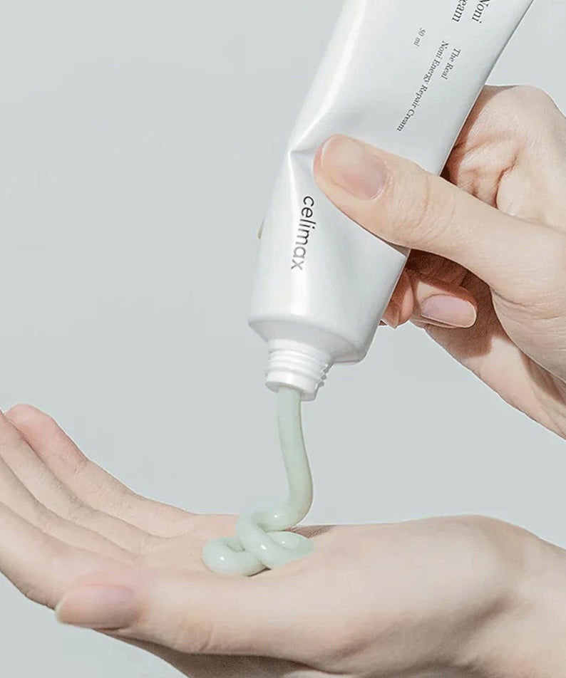 Applying CELIMAX The Real Noni Energy Repair Cream 50ml to skin from tube