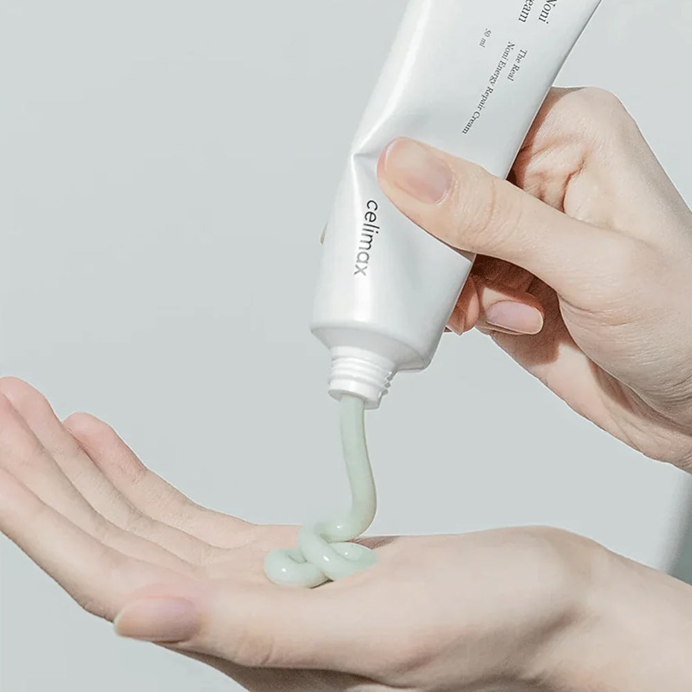 Applying CELIMAX The Real Noni Energy Repair Cream 50ml to skin from tube