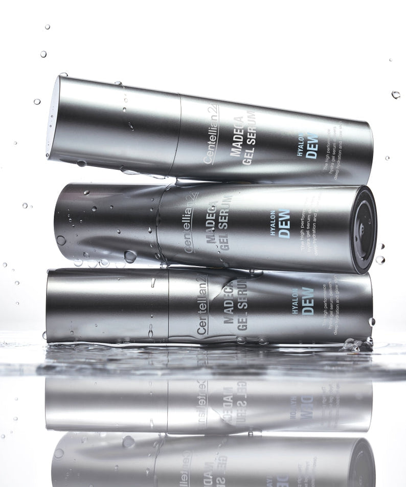 Three bottles of CENTELLIAN 24 Madeca Gel Serum Hyalon Dew 30ml stacked with water droplets, showcasing the product’s design and texture.
