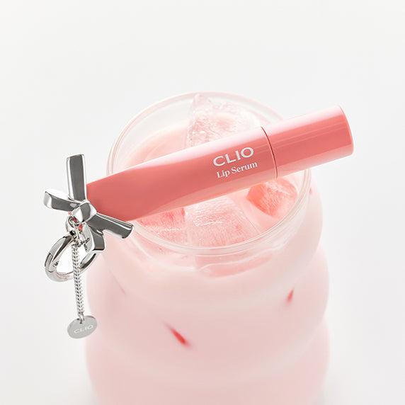 CLIO Glaze Lip Serum on a pink drink with a charm accessory