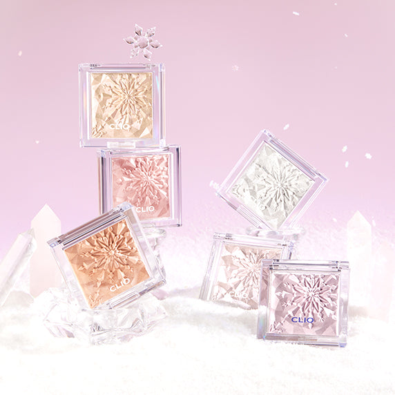 Various shades of CLIO Prism Highlighter on a frosty pink background, showcasing intricate snowflake designs in clear cases.