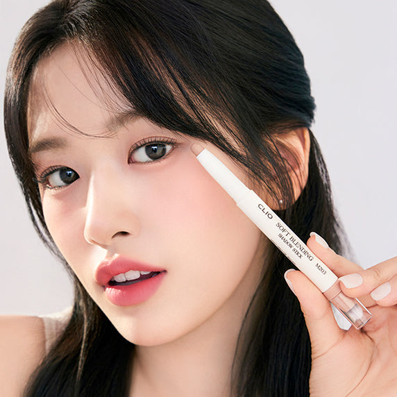 Woman applying CLIO Soft Blending Shadow Stick to eyelids, showcasing smooth application and vibrant color payoff.