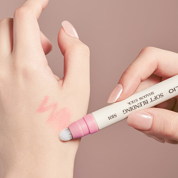 Applying CLIO Soft Blending Shadow Stick on hand for a smooth eye shadow finish.