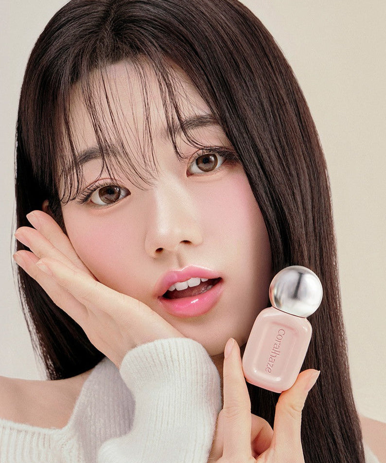 Woman holding CORALHAZE Dew Drop Tint 4.5g, showcasing its elegant packaging.