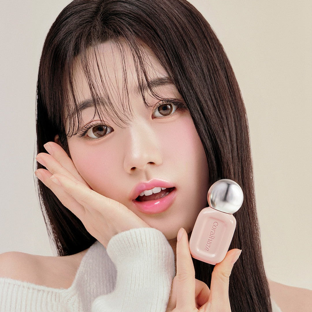 Woman holding CORALHAZE Dew Drop Tint 4.5g, showcasing its elegant packaging.