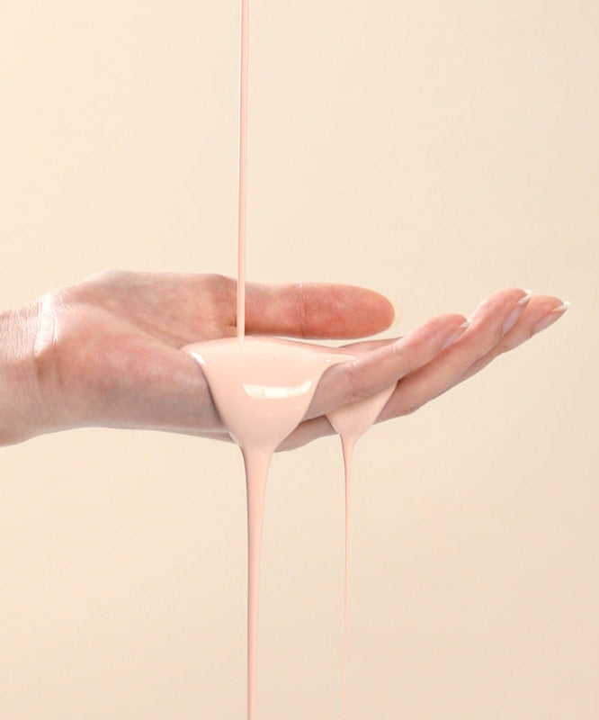 CORALHAZE SIlky Glow Tone Up Base texture flowing on hand, showcasing its smooth and silky formulation for radiant skin.