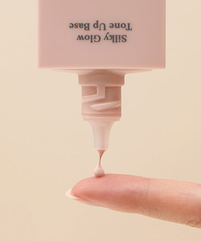 CORALHAZE SIlky Glow Tone Up Base being applied to finger for a radiant finish