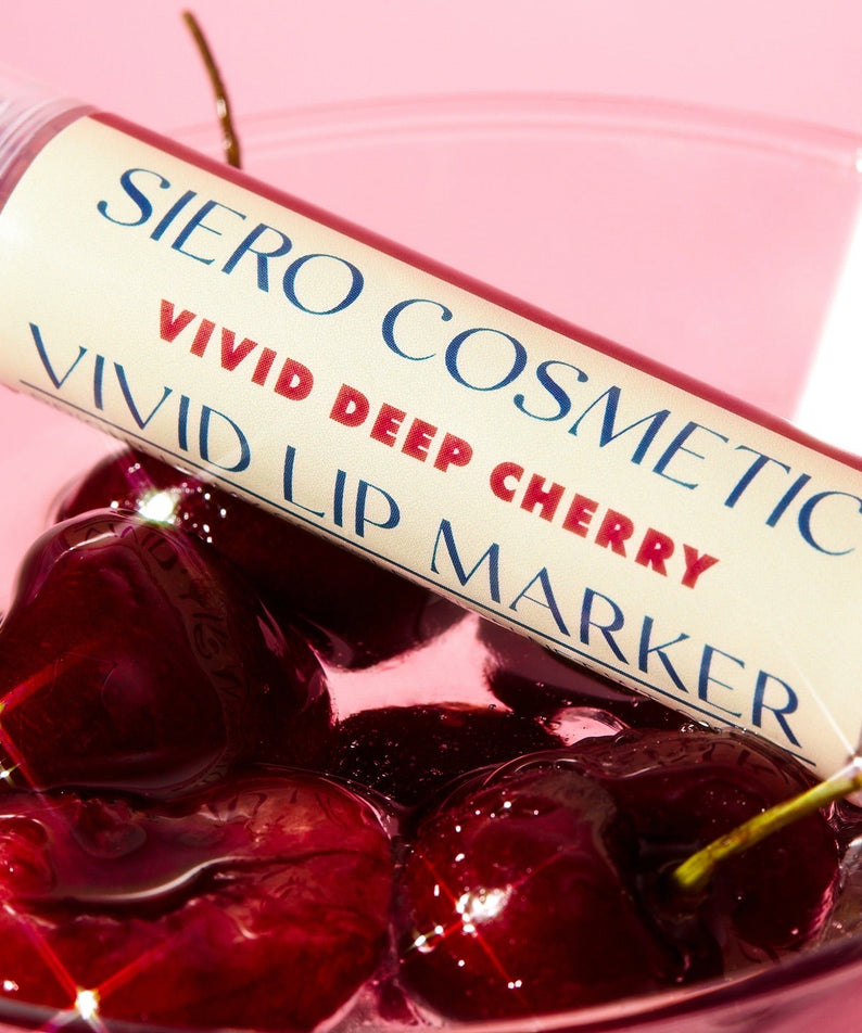 COSIERO Vivid Lip Marker in Deep Cherry shade resting on fresh cherries, showcasing vibrant lip color and fruity inspiration.