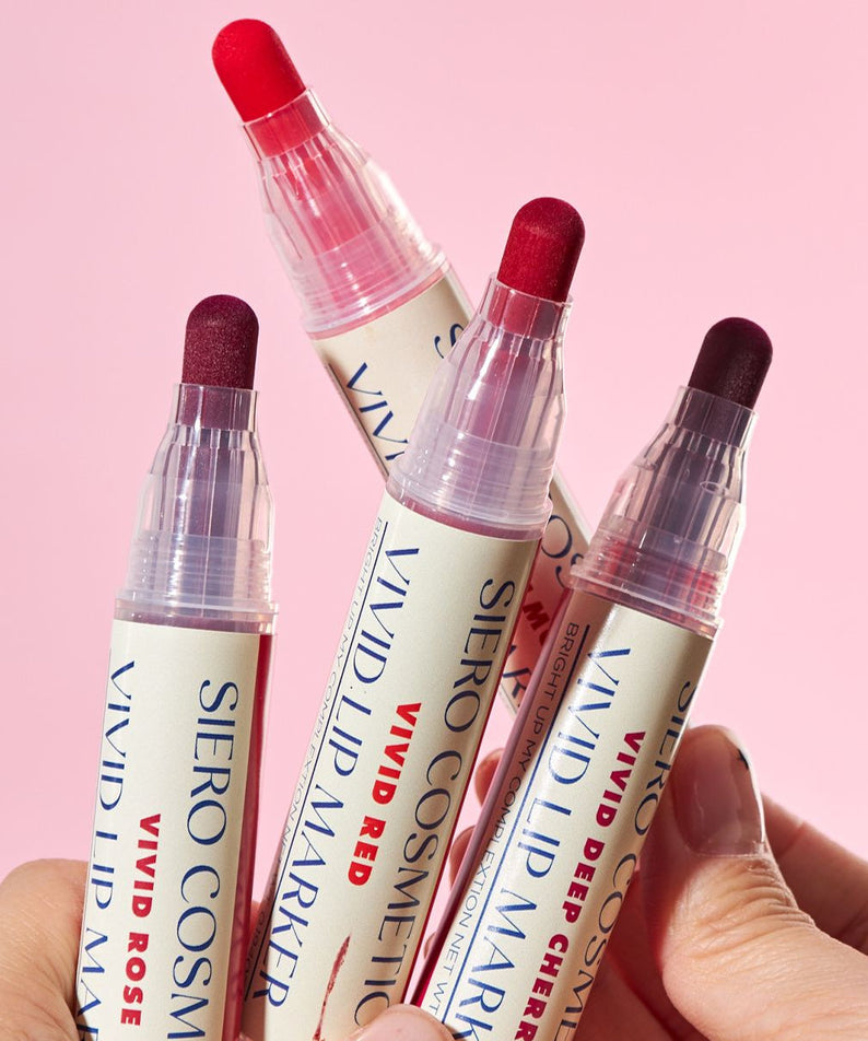 COSIERO Vivid Lip Marker in four vibrant shades held against a pink background.