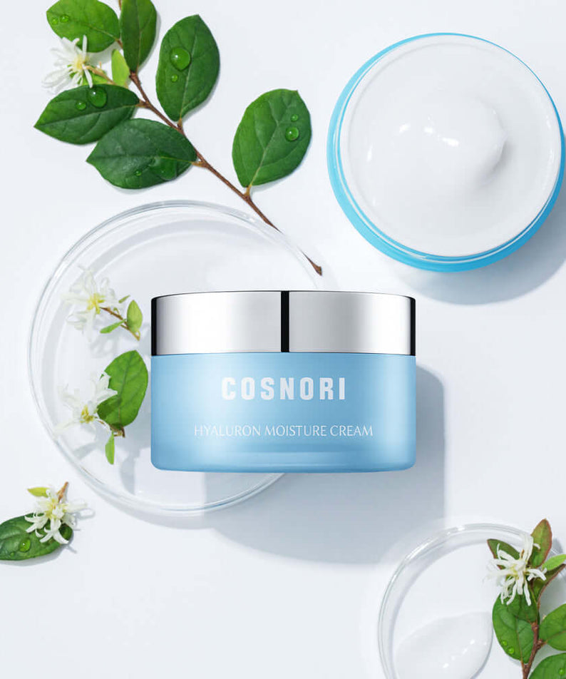 COSNORI Hyaluronic Moisture Cream 50ml container surrounded by green leaves on a white background