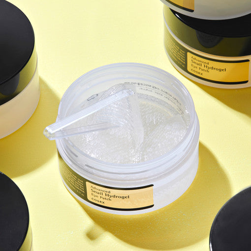 COSRX Advanced Snail Hydrogel Eye Patch 60p 90g open container on yellow background