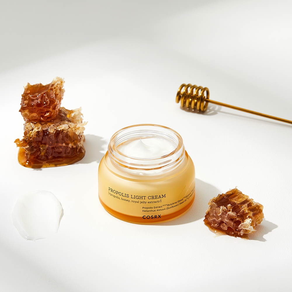 COSRX Full Fit Propolis Light Cream 65ml on a white background with honeycomb and a honey dipper.