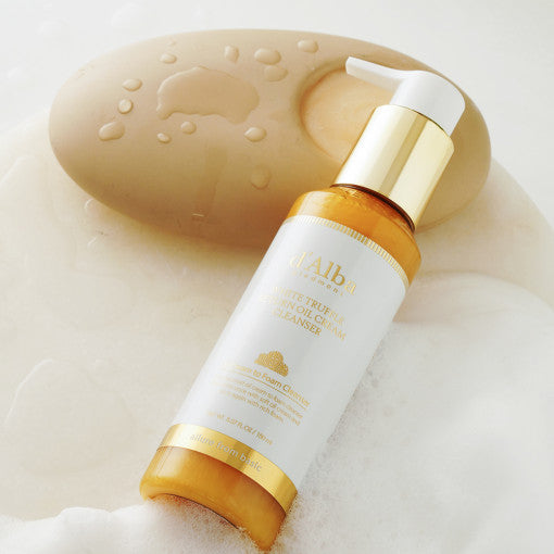 D'ALBA Return Oil Cream Cleanser 100ml with luxurious packaging on a soapy background.