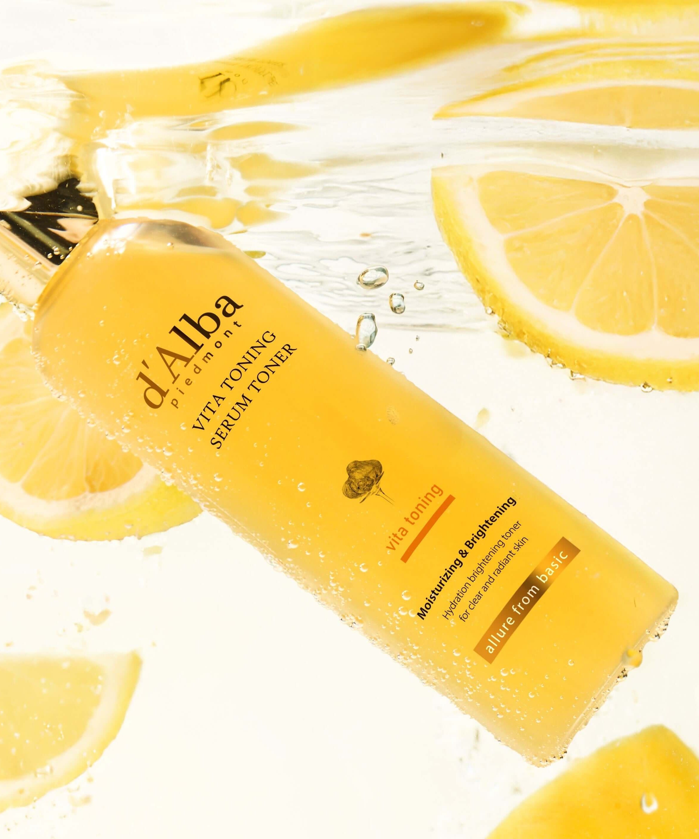 D'ALBA Vita Toning Serum Toner 180ml submerged in water with lemon slices, highlighting fresh and hydrating properties.