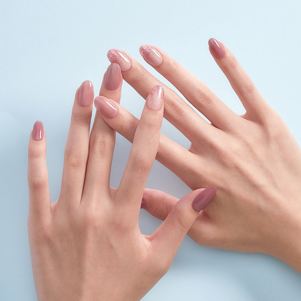 Elegant nails showcasing DASHING DIVA MAGIC PRESS Lovely Muse - Long Oval in soft pink hues on a pale blue background.