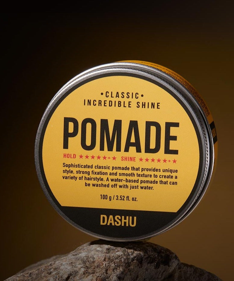 DASHU Classic Incredible Shine Pomade 100g - Gentleman Korea product shot of yellow tin on rock, classic high-shine men’s styling wax