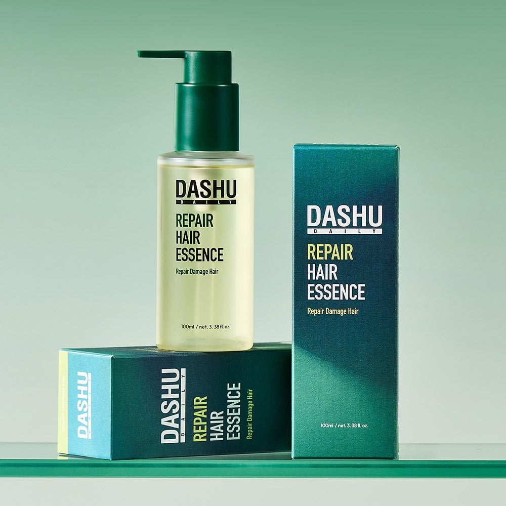 DASHU Daily Repair Hair Essence 100ml bottle with packaging displayed on a green background.