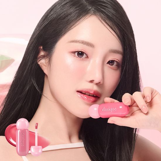Woman showcasing DASIQE Dewy Glow Tint on lips with product packaging in the foreground.