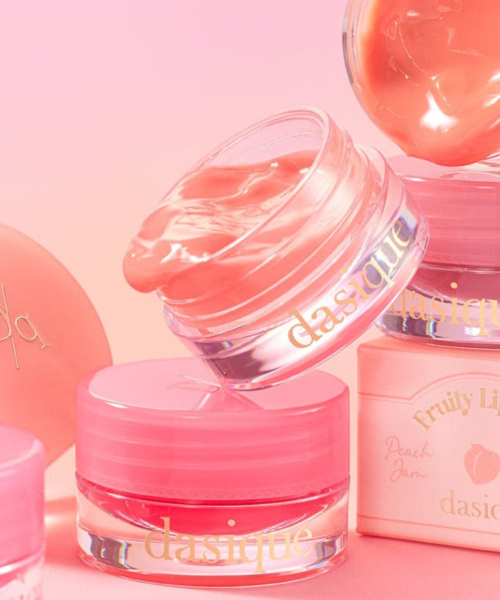 DASIQUE Fruity Lip Jam in peach and pink shades against a soft pink background, showcasing the product's texture and packaging.