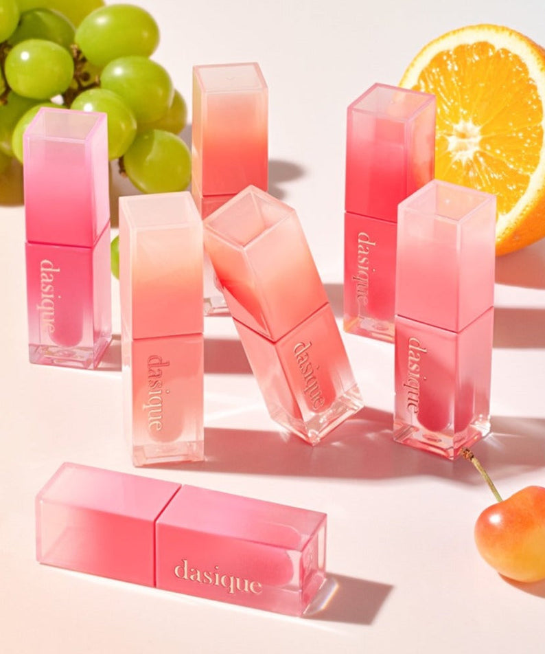 Collection of DASIQUE Juicy Dewy Tint products with vibrant fruit accents in the background.