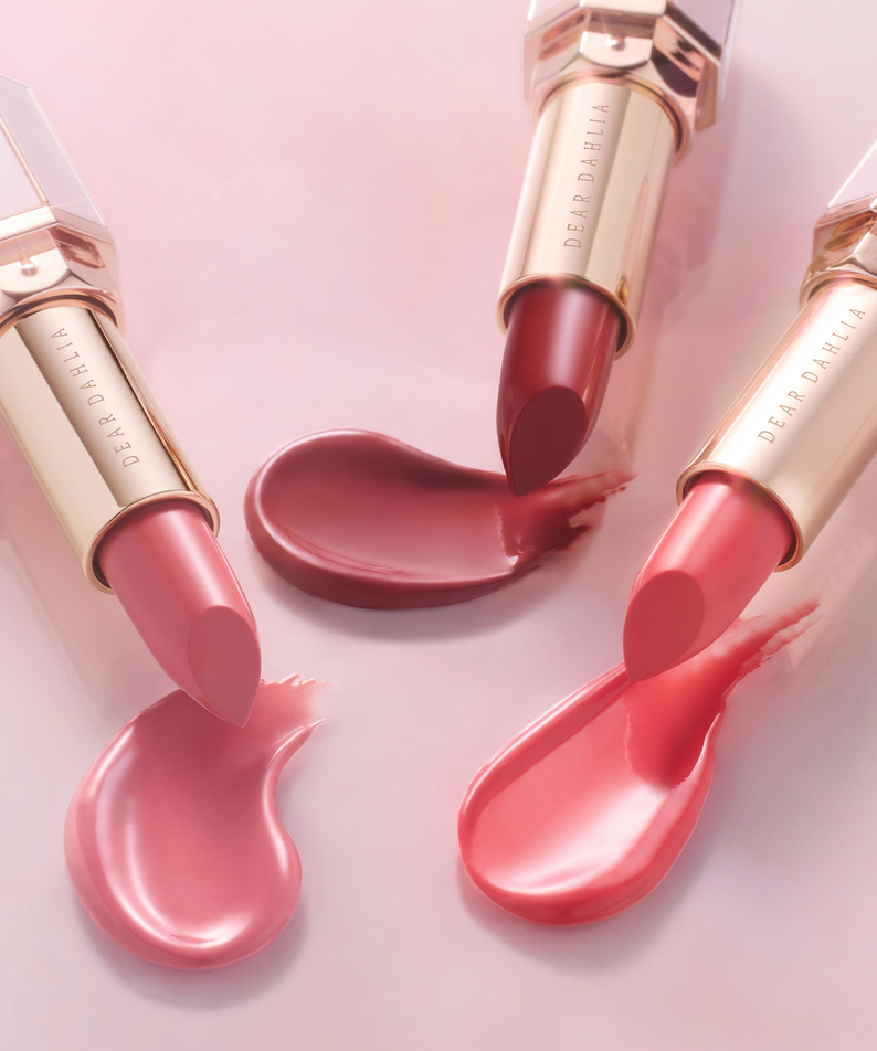 DEAR DAHLIA Lip Paradise Sheer Dew Lipstick in various shades on a pink background