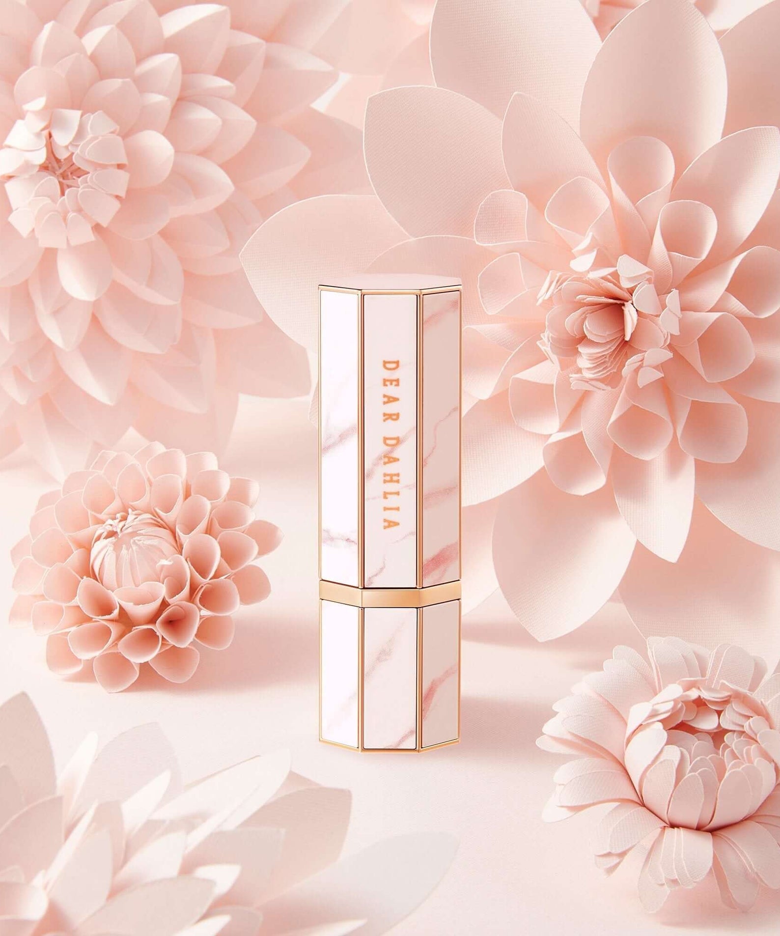 Luxury DEAR DAHLIA Paradise Blooming Night lipstick surrounded by delicate pink dahlia flowers, highlighting elegance and beauty.