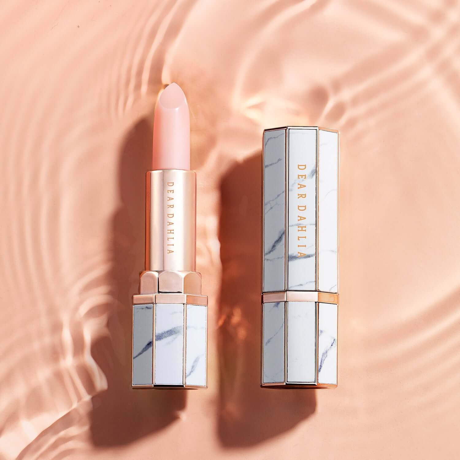 DEAR DAHLIA Paradise Blooming Night lipstick elegantly displayed on a peach background with water ripple effect.
