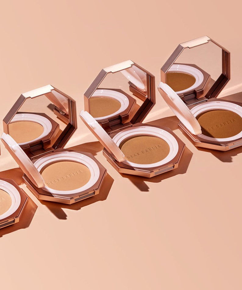 Open DEAR DAHLIA Soft Velvet Setting Powder Compact showing the powder and mirror, placed on a peach background.