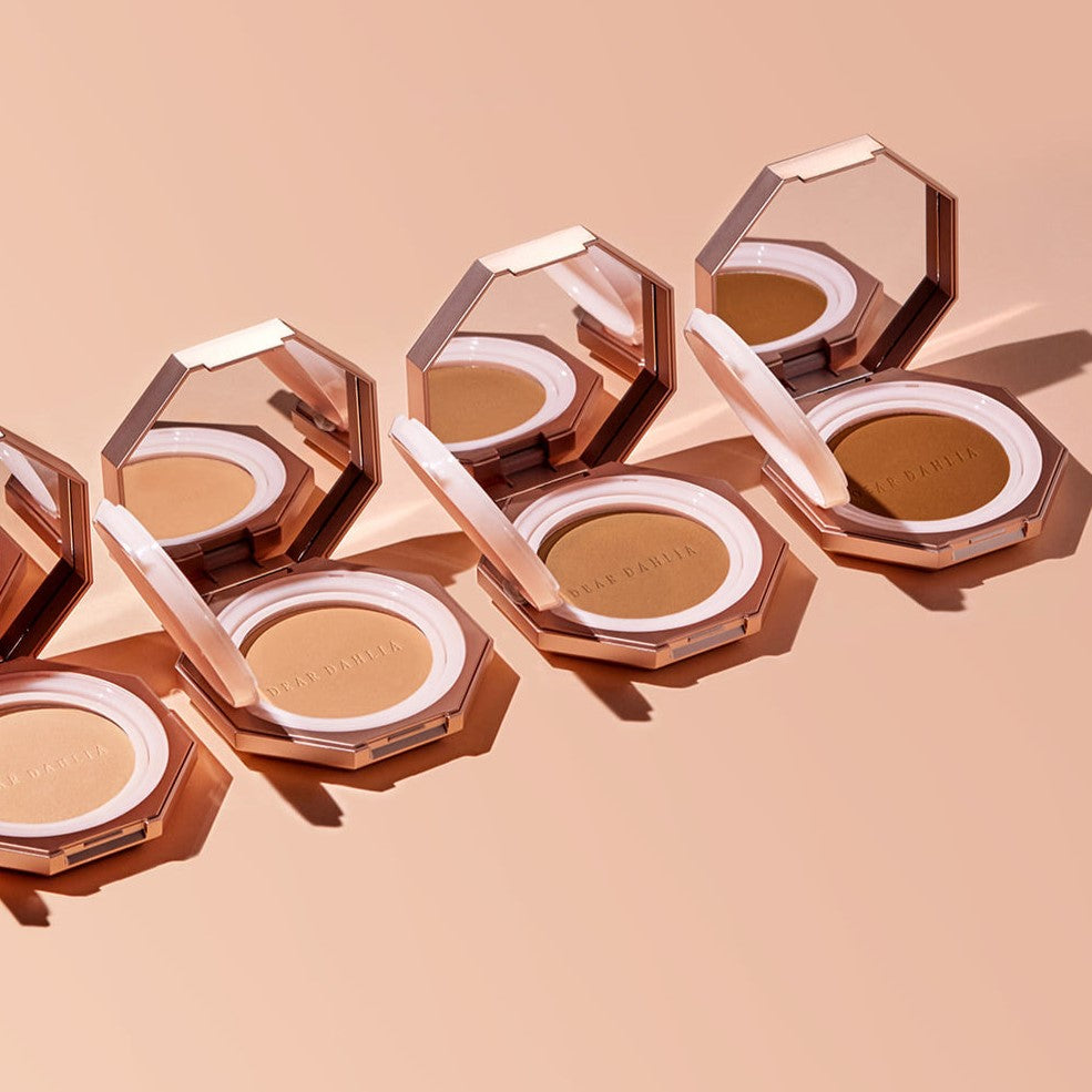 Open DEAR DAHLIA Soft Velvet Setting Powder Compact showing the powder and mirror, placed on a peach background.