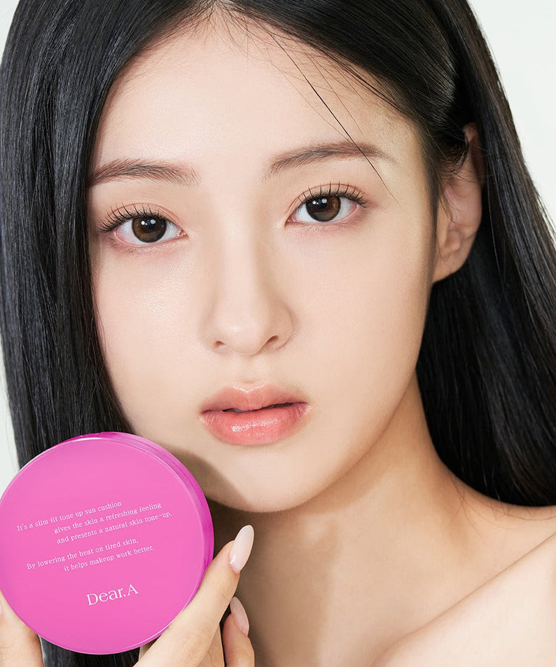 Model holding DEAR.A Slim Fit Tone-Up Sun Cushion 30ml, showcasing lightweight and protective skincare in vibrant packaging.