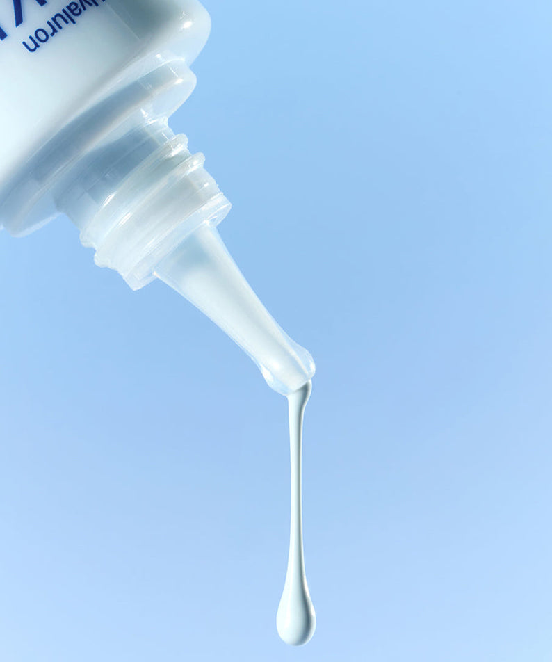 Close-up of DERMATORY Hyaluronic Skin Prep Sun Cream B5 52ml with drop against blue background