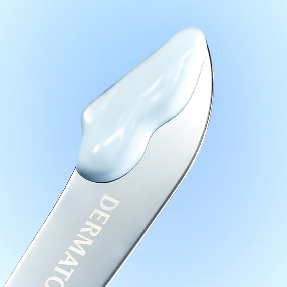 Close-up of DERMATORY Hyaluronic Skin Prep Sun Cream B5 52ml texture on applicator against blue background.