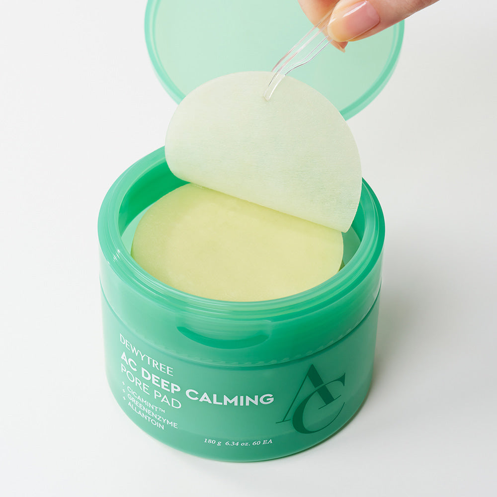 Open jar of DEWYTREE AC Deep Calming Pore Pad 60 Pads with one pad being held up, showing circular design and packaging.